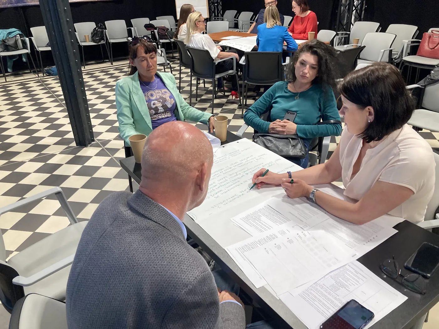 Urzędnicy pracują w podgrupach nad arkuszami podczas warsztatu sieci uczenia się, czerwiec 2023